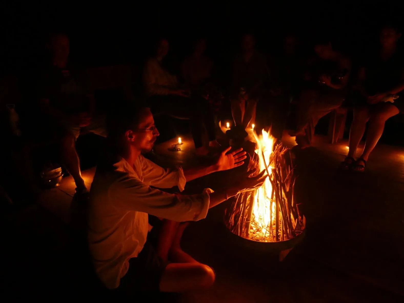 A fire ceremony at night — guests gathered around the flames.