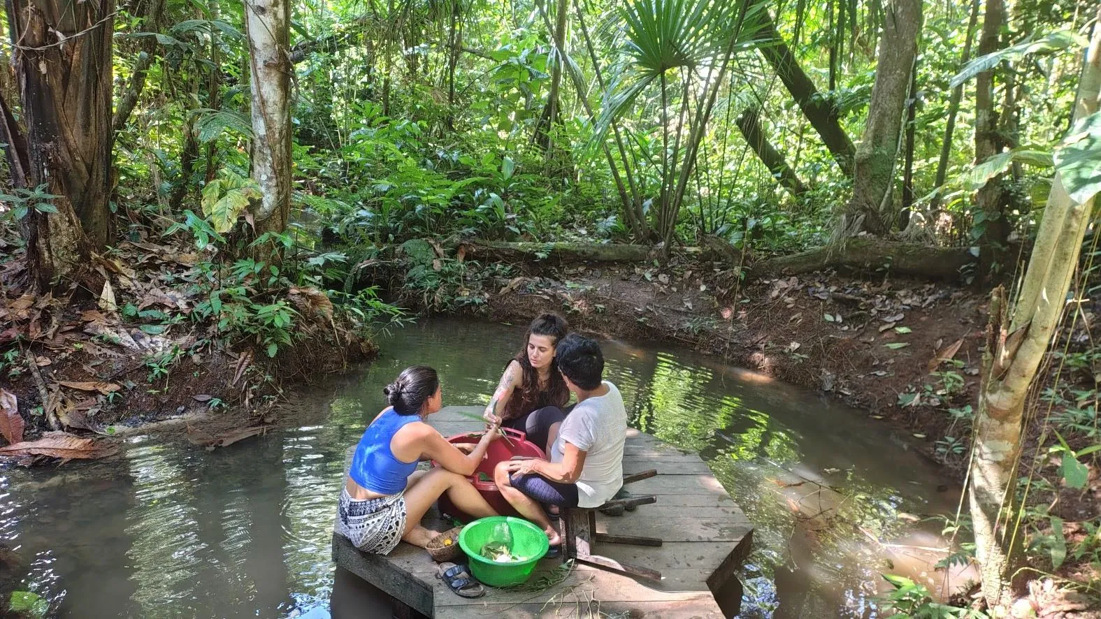 Guests and family together by a jungle stream at Ayaselva.