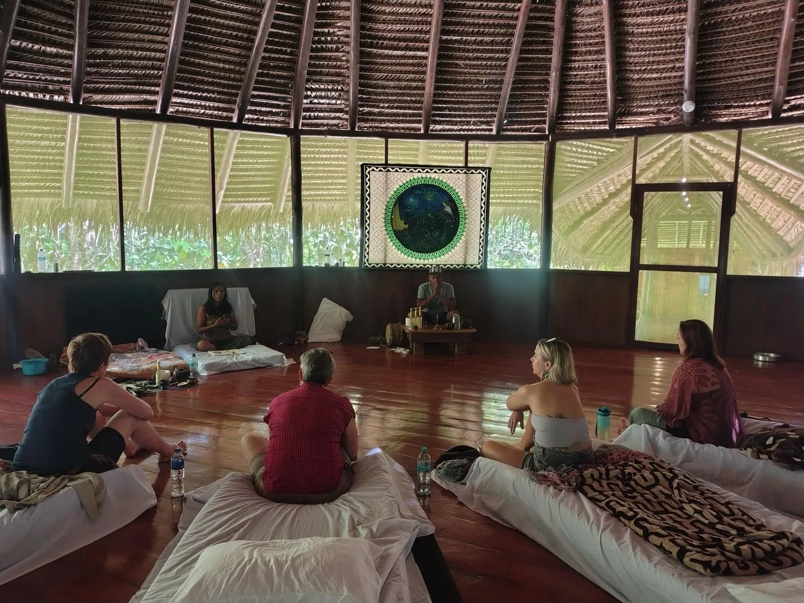 A sharing circle inside the maloka — guests resting and reflecting together the day after a ceremony.